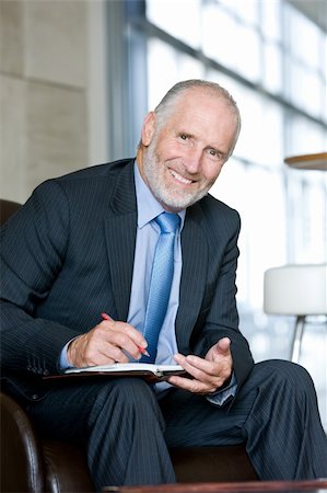 simsearch:400-04111366,k - Portrait of smiling Senior business man writing on notepad Foto de stock - Royalty-Free Super Valor e Assinatura, Número: 400-04606214