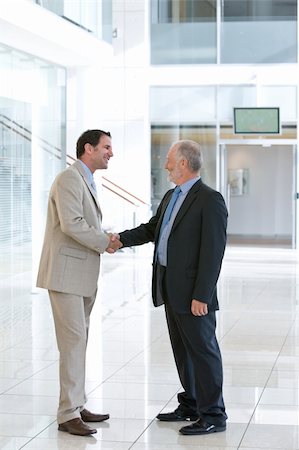 simsearch:400-04606211,k - Two business men shaking hands in front of big glass window Stockbilder - Microstock & Abonnement, Bildnummer: 400-04606210