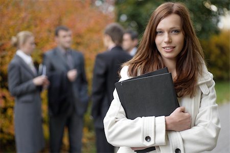 simsearch:400-05155599,k - Business woman in an outdoor environment with colleagues on the background at autumn time Stock Photo - Budget Royalty-Free & Subscription, Code: 400-04606983