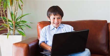 Child playing with his laptop on the sofa Foto de stock - Super Valor sin royalties y Suscripción, Código: 400-04607568