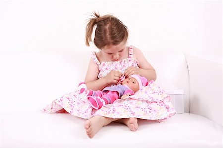 Beautiful small girl playing with doll Stock Photo - Budget Royalty-Free & Subscription, Code: 400-04607993