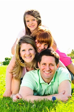 simsearch:400-04115211,k - Portrait of happy family of four laying on grass at the park Foto de stock - Super Valor sin royalties y Suscripción, Código: 400-04608831