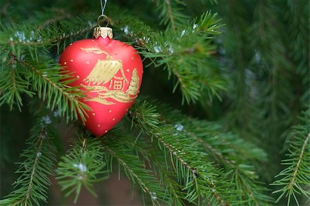 round ornament hanging of a tree - Heart shape christmas-tree decoration on green coniferous tree Stock Photo - Budget Royalty-Free & Subscription, Code: 400-04608897