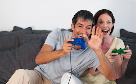 simsearch:400-05059261,k - Young Couple on Sofa Playing Video Games Stock Photo - Budget Royalty-Free & Subscription, Code: 400-04600706