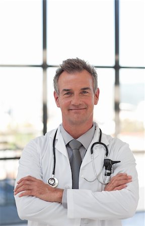 simsearch:400-05192323,k - Potrait of a Mature senior Doctor in a hospital Smiling at camera Stock Photo - Budget Royalty-Free & Subscription, Code: 400-04601288