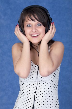 Girl listening music in earphones on the blue background Stock Photo - Budget Royalty-Free & Subscription, Code: 400-04601627