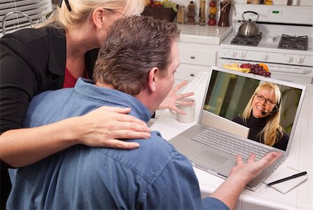 Couple In Kitchen Using Laptop with Customer Support Woman on the Screen. Stock Photo - Budget Royalty-Free & Subscription, Code: 400-04602504