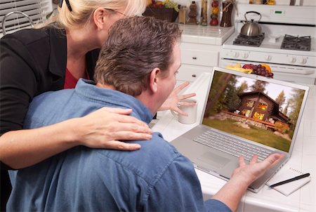 Couple In Kitchen Using Laptop with Lake Cabin on the Screen. Stock Photo - Budget Royalty-Free & Subscription, Code: 400-04602503