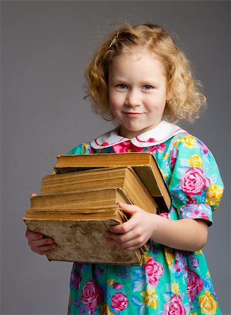 simsearch:400-04637418,k - Preschool girl carrying old books, on greay background Stock Photo - Budget Royalty-Free & Subscription, Code: 400-04602958