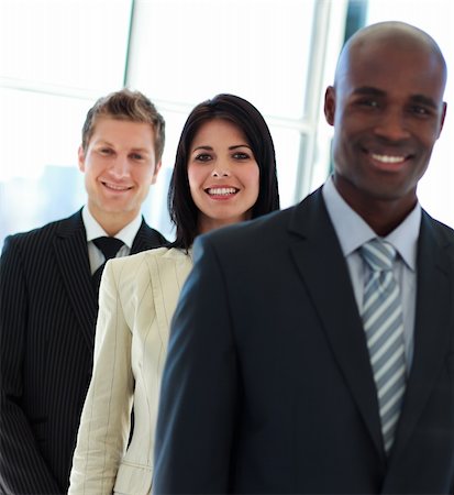 Smiling young  businesswoman in focus with her team in a row Photographie de stock - Aubaine LD & Abonnement, Code: 400-04614508