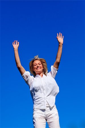 simsearch:400-04450996,k - Carefree young woman enjoying life against blue sky Stock Photo - Budget Royalty-Free & Subscription, Code: 400-04614599