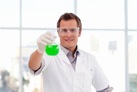 simsearch:400-03952161,k - Young smiling scientist examining a chemical test-tube Stock Photo - Budget Royalty-Free & Subscription, Code: 400-04614652