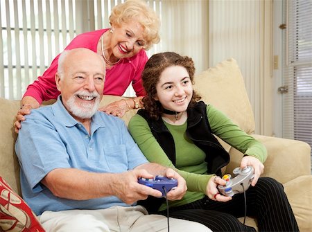Senior couple has fun playing video games with their teenage granddaughter. Stock Photo - Budget Royalty-Free & Subscription, Code: 400-04614664