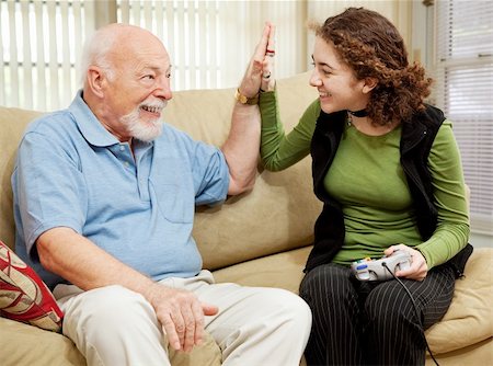 Teen girl playing video games, getting a high five from her grandfather. Stock Photo - Budget Royalty-Free & Subscription, Code: 400-04614667