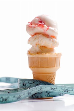 Concept image of a diet featuring an ice cream cone with strawberry ice cream and a measuring tape shot on white Stock Photo - Budget Royalty-Free & Subscription, Code: 400-04615918