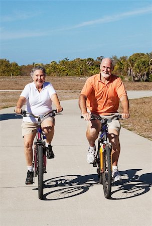 Senior couple has fun riding their bicycles on a tropical vacation. Foto de stock - Super Valor sin royalties y Suscripción, Código: 400-04616227