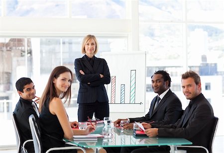 simsearch:400-04918393,k - Serious businesswoman looking at the camera in a meeting with her team Stock Photo - Budget Royalty-Free & Subscription, Code: 400-04616488