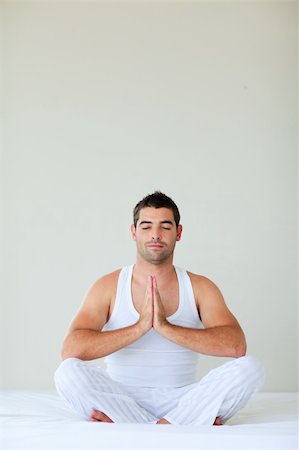 Attractive young man doing yoga in bed with clossed eyes Stock Photo - Budget Royalty-Free & Subscription, Code: 400-04616490