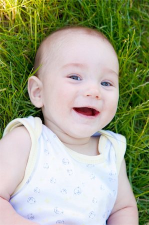 simsearch:400-06768635,k - Portrait of a laughing baby lying in the grass Foto de stock - Royalty-Free Super Valor e Assinatura, Número: 400-04616888