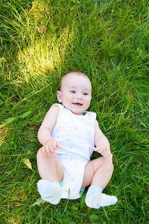 Smiling baby lies in the green grass Foto de stock - Super Valor sin royalties y Suscripción, Código: 400-04616889