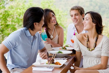 Four young adults enjoying a meal together on vacation Stock Photo - Budget Royalty-Free & Subscription, Code: 400-04617460