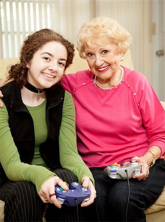 simsearch:400-04300757,k - Grandmother and teen granddaughter bonding by playing video games together. Photographie de stock - Aubaine LD & Abonnement, Code: 400-04618402