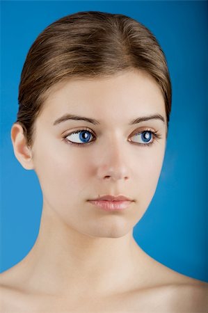 simsearch:400-05192072,k - Close up portrait of a beautiful female model looking to the side isolated on a blue background Photographie de stock - Aubaine LD & Abonnement, Code: 400-04618799
