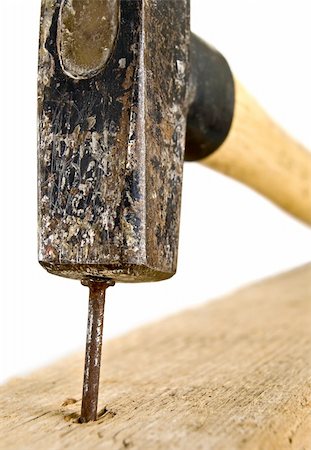 closeup of a hammer hitting the nail,over white background,shallow DOF Stockbilder - Microstock & Abonnement, Bildnummer: 400-04618818