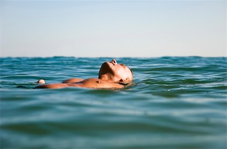 simsearch:400-04956125,k - Aman in his forties is relaxing or meditating as he floats on his back in the beautiful turquoise sea. Stock Photo - Budget Royalty-Free & Subscription, Code: 400-04618924