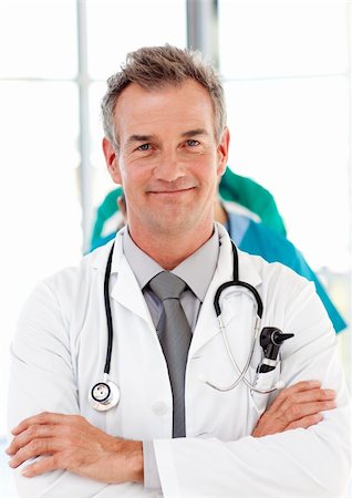 Senior doctor with folded arms leading his team Stock Photo - Budget Royalty-Free & Subscription, Code: 400-04610002