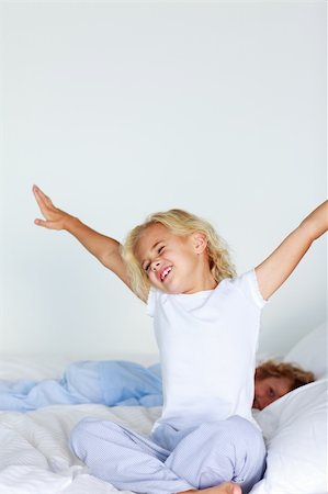 reading while stretching - Little girl stretching her arms in bed Stock Photo - Budget Royalty-Free & Subscription, Code: 400-04610017