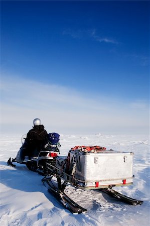 simsearch:400-05140122,k - A man sitting on a snowmobile on a barren snow landscape Photographie de stock - Aubaine LD & Abonnement, Code: 400-04610532
