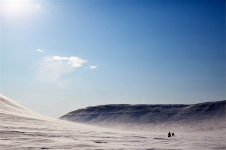 simsearch:400-05140080,k - A barren winter landscape with two snowmobiles travelling accross the horizon Fotografie stock - Microstock e Abbonamento, Codice: 400-04610547