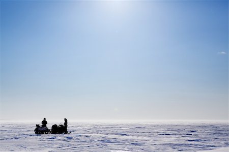 simsearch:400-05140080,k - A barren flat winter landscape with two people and snowmobiles Fotografie stock - Microstock e Abbonamento, Codice: 400-04610549