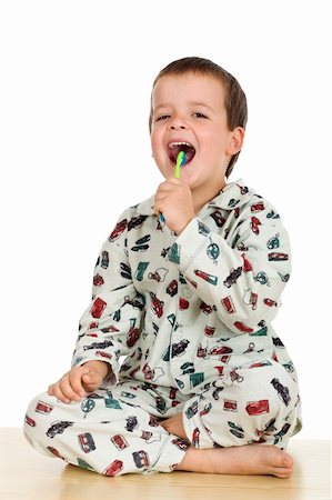 Happy kid dressed in his pajamas brushing teeth before going to bed - isolated Stock Photo - Budget Royalty-Free & Subscription, Code: 400-04610722