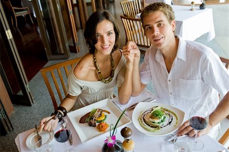 eastwestimaging (artist) - A young couple sitting together in a restaurant holding hands Fotografie stock - Microstock e Abbonamento, Codice: 400-04611281