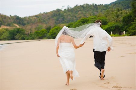 A young couple just married on the beach running away Foto de stock - Super Valor sin royalties y Suscripción, Código: 400-04611334