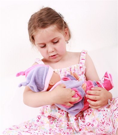 Beautiful small girl playing with doll Stock Photo - Budget Royalty-Free & Subscription, Code: 400-04611419