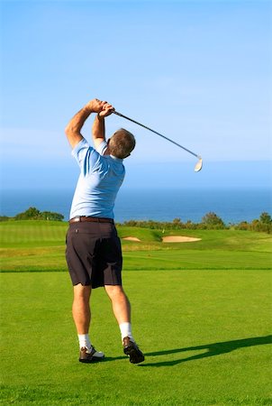 simsearch:400-04942072,k - Senior male golfer playing golf from the tee box next to the ocean on a beautiful summer day Foto de stock - Royalty-Free Super Valor e Assinatura, Número: 400-04611547