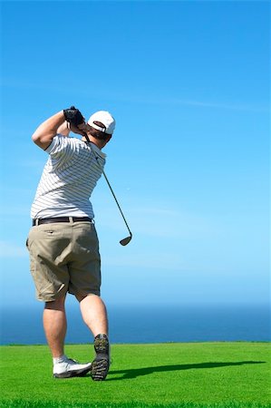 simsearch:400-05038623,k - Young male golfer hitting the ball from the tee box next to the ocean on a beautiful summer day Stock Photo - Budget Royalty-Free & Subscription, Code: 400-04611548