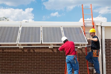 simsearch:400-04485314,k - Workers installing solar panels on the side of a building.  Wide angle view with room for text. Fotografie stock - Microstock e Abbonamento, Codice: 400-04612334