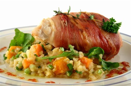 simsearch:400-04613511,k - Chicken wrapped in prosciutto on pumpkin and rocket risotto. Fotografie stock - Microstock e Abbonamento, Codice: 400-04613519