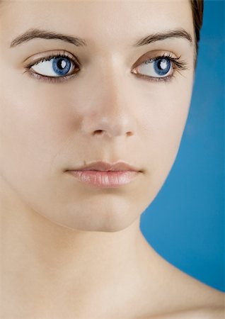 simsearch:400-05192073,k - Close up portrait of a beautiful female model isolated on a blue background Photographie de stock - Aubaine LD & Abonnement, Code: 400-04613872