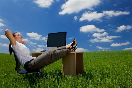 relaxed attractive woman feet up - Business concept shot of a beautiful young woman relaxing at a desk in a green field with a bright blue sky. Shot on location. Photographie de stock - Aubaine LD & Abonnement, Code: 400-04613933