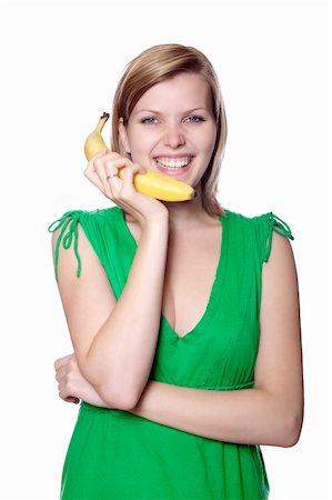 pretty women eating banana - Pretty girl in a green dress is holding a banana as a phone, isolated on white Stock Photo - Budget Royalty-Free & Subscription, Code: 400-04625700
