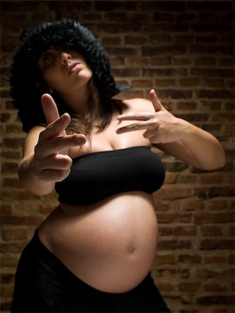 A young pregnant woman gesturing as she was armed. Focus on the hand. Stock Photo - Budget Royalty-Free & Subscription, Code: 400-04627469