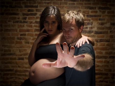 simsearch:400-04205919,k - A man try to stop the picture to be taken.Woman on her eighth month of pregnancy. Focus on hand. Stock Photo - Budget Royalty-Free & Subscription, Code: 400-04627471