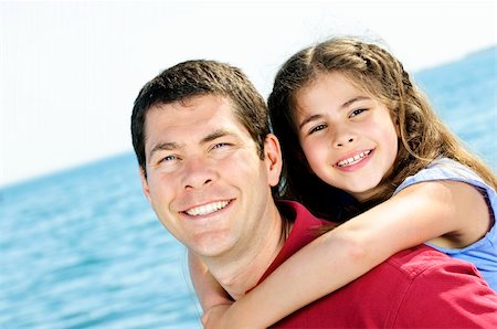 piggyback daughter at beach - Portrait of father giving piggyback ride to daughter at seashore Stock Photo - Budget Royalty-Free & Subscription, Code: 400-04628401