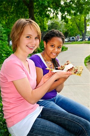 Two teenage girls sitting and eating pizza Stock Photo - Budget Royalty-Free & Subscription, Code: 400-04628979