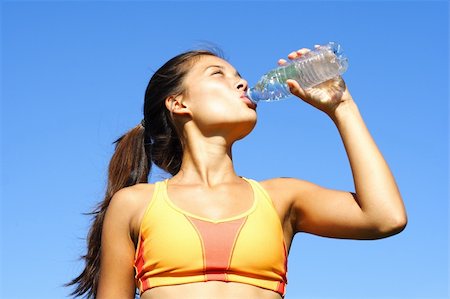 Sporty mixed asian / caucasian drinking and relaxing after running outdoor under a hot summer sun. Photographie de stock - Aubaine LD & Abonnement, Code: 400-04629621